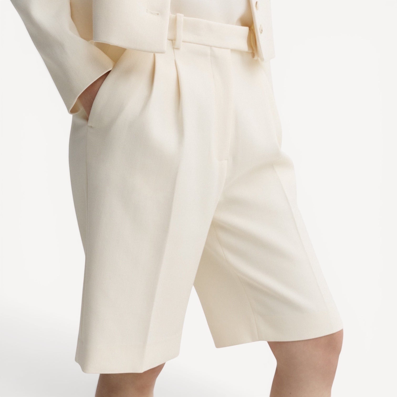 Lula Studio Prague cream woven blend tailored shorts with front pleats and adjustable side tabs.